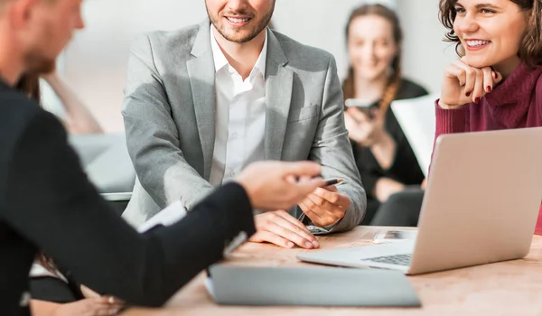 Grupo de trabajo está discutiendo algo mientras está sentado en su escritorio — Foto de Stock