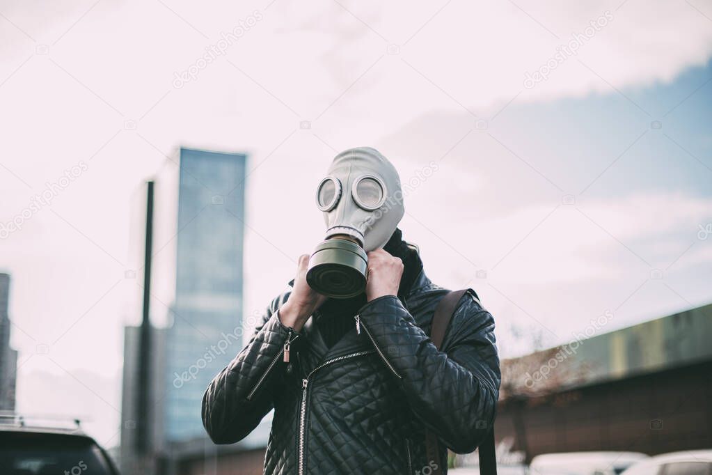 young man wearing a gas mask on a city street