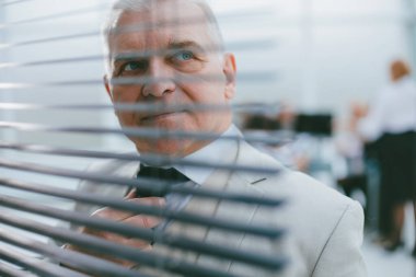 Sorumlu, başarılı iş adamı perdelerden bakıyor. iş kavramı