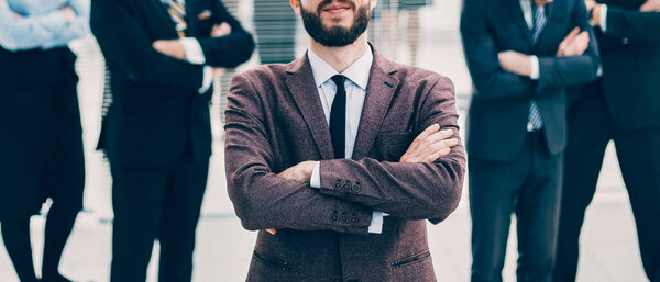 улыбающийся бизнесмен, стоящий перед бизнес-командой