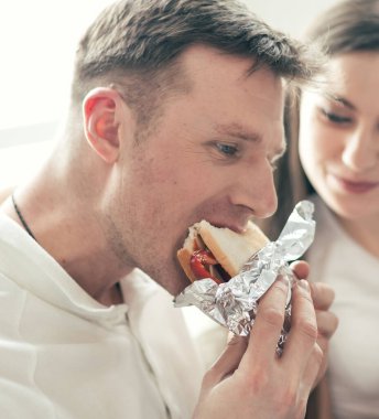 Kapat. Genç çift kanepede oturmuş bir şeyler tartışıyorlar..