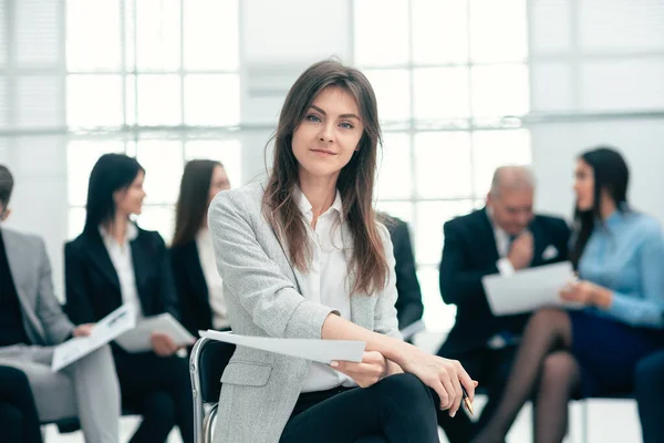 Giovane donna d'affari sullo sfondo dei suoi colleghi. — Foto Stock