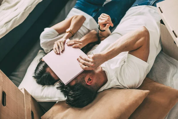 Pareja descansando en el suelo, el día de mudarse a un nuevo apartamento. — Foto de Stock