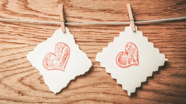 Dos hojas en blanco con corazones pintados en una cuerda — Foto de Stock