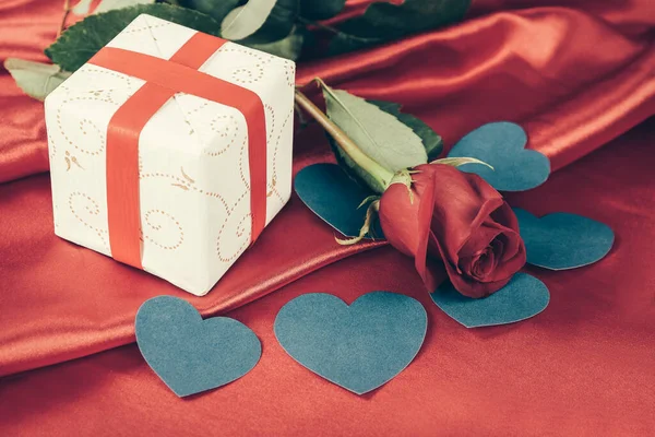 Red rose and gift box on red background. — Stock Photo, Image