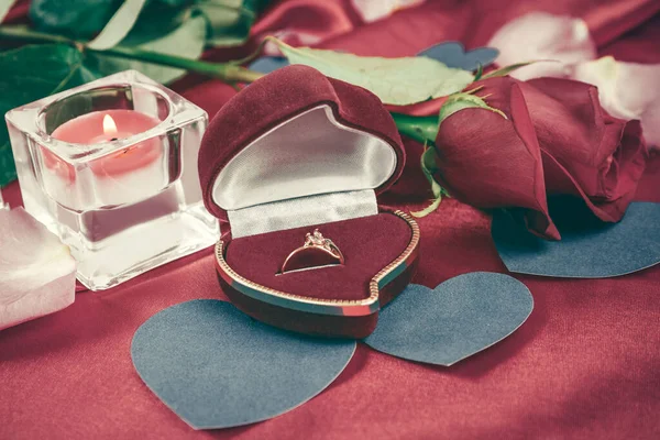 Two candles and a rose on a red silk background — Stock Photo, Image