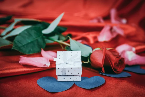 Rosa e caixa de presente no fundo vermelho. — Fotografia de Stock