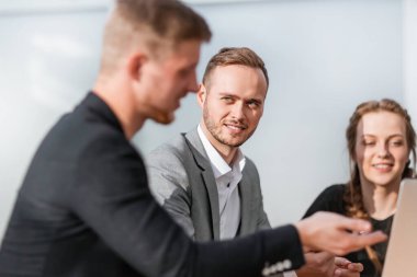 Kapat. Genç meslektaşlar iş toplantısında dizüstü bilgisayar kullanıyorlar..