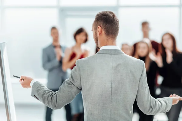 Вид сзади. the speaker is standing by the flipchart. — стоковое фото