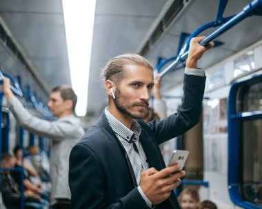 Delikanlı metroda yazışmalarını okuyor. .