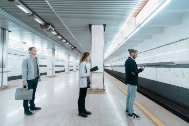 çeşitli metro yolcuları trenin gelişini bekliyorlar. .
