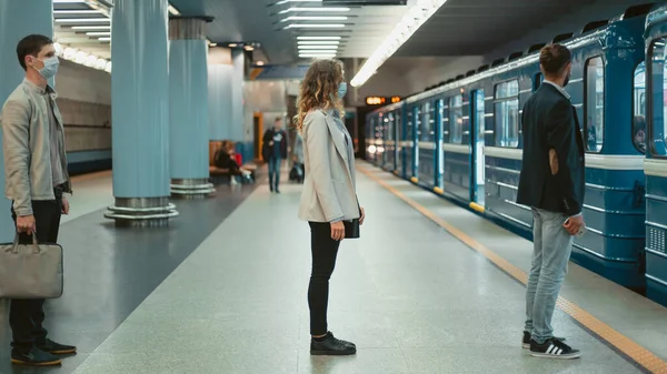 Menschen in Schutzmasken stehen auf dem U-Bahnsteig . — Stockfoto