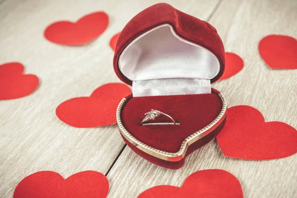 Anillo en caja roja sobre fondo de madera claro —  Fotos de Stock