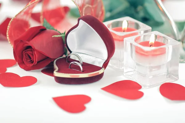 Alianças de casamento, velas e rosa no fundo branco — Fotografia de Stock