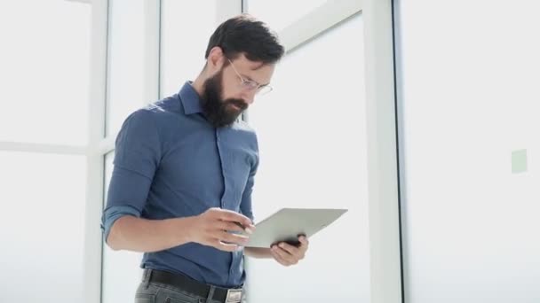 Uomo d'affari legge un documento in piedi in ufficio. — Video Stock