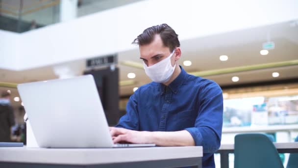 Эмоциональный человек в маске, работающий над ноутбуком . — стоковое видео