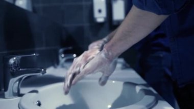 Çalışanlar ellerini musluğun altında iyice yıkıyor..