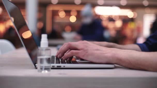 Freelancer masculino trabalha em um laptop à noite em um café. close - up . — Vídeo de Stock