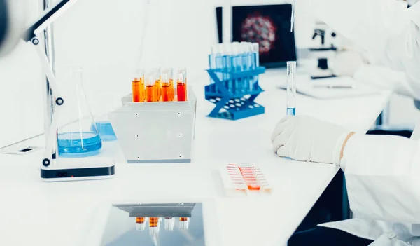 Tabletas digitales y ampollas con la vacuna sobre la mesa en el laboratorio. — Foto de Stock