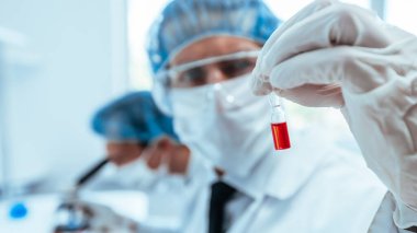 Bilim adamı mikroskopla bir kontrol örneğine bakıyor..