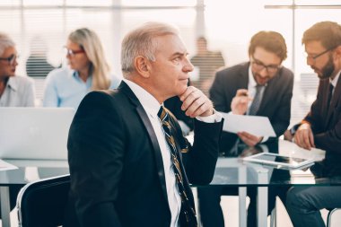 Kapat. Ofiste oturan düşünceli iş adamı..