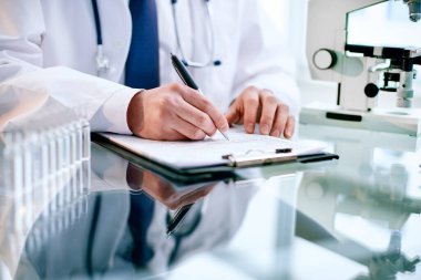 Yakın plan. Bilim adamı çalışmanın sonuçlarını panoya yazıyor..