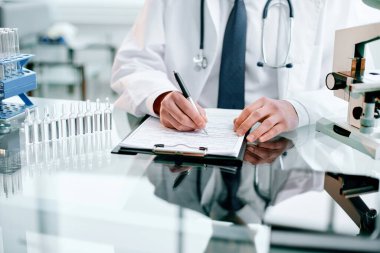 Yakın plan. Bilim adamı çalışmanın sonuçlarını panoya yazıyor..