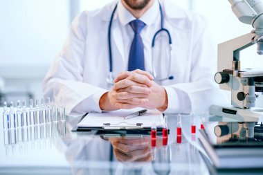 Bilim laboratuarındaki bir masada oturan bilim adamı.