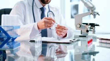 Bilim adamı yeni aşıyla ampulü incelikle inceliyor..