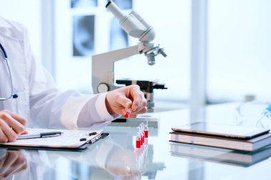 Bilim adamı yeni bir aşıyla numunelere bakıyor..