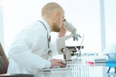 Laboratuvarda kan örneklerini inceleyen bir bilim adamı. yan görünüm.