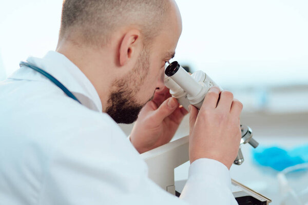 scientist using a digital tablet sitting at a laboratory table.