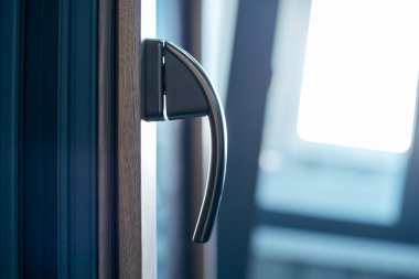 Yakın plan. Pencere çerçevesindeki metal kol.