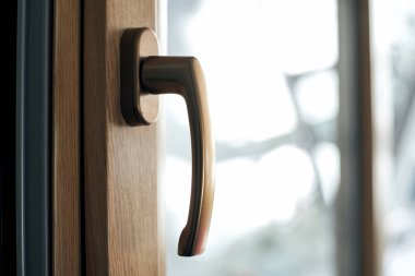 Pencere çerçevesinde altın renginde şık tutuş.