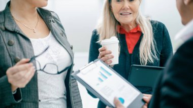 Kapat. çalışanlar kahve molasında mali verileri tartışıyor