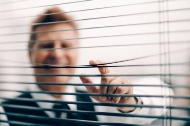 Kapat. Ofis penceresinden bakan mutlu bir iş adamı.