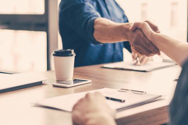 Koruyucu maskeli genç iş ortakları el sıkışıyor..