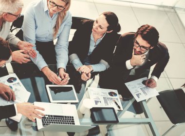 İş arkadaşları iş belgeleriyle çalışmak için dijital tablet kullanıyorlar.