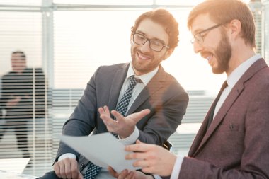 İki iş adamı bir iş belgesini tartışıyor.