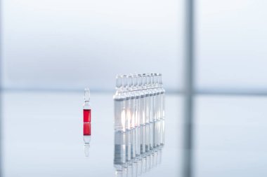 Laboratuvardaki masanın üzerinde cam ampuller var..