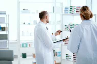 Kadın ve erkek eczacı. Yeni ilaçları tartışıyorlar. .