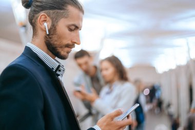 İş adamı metroda akıllı telefonunu kullanıyor..