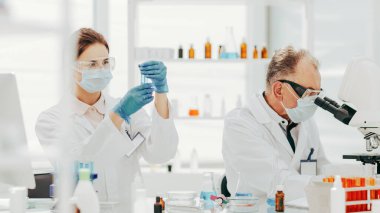 Bir grup bilim adamı bir tıp laboratuarında kan testleri yapıyor. .