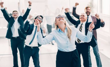 Sevinçli bir grup çalışan ofiste duruyor..