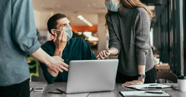 employees in protective masks discussing work issues.