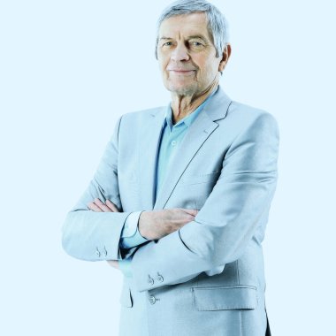 Yaşına göre iyi bir işadamı, gülümsüyor ve kollarını kavuşturarak kameraya poz veriyor.