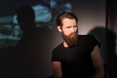 Düşünceli sakallı adamın portresi Sandalyede oturan motorcu