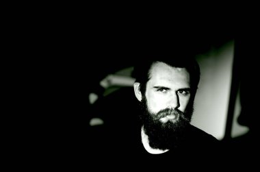 Siyah tişörtlü, ciddi bir motorcunun portresi..