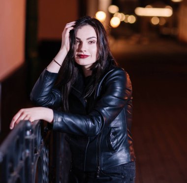 Rüya gören genç bir kadın Gece şehrinde duruyor