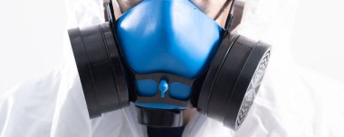 Yakın plan. Erkek dezenfektanının yüzünde antiviral maske var..